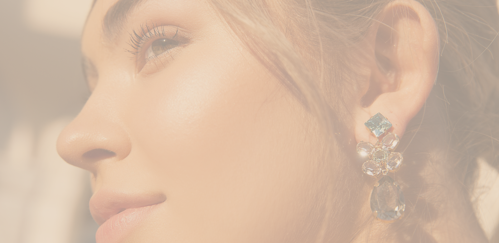 Close-up of woman's face with elegant earrings.